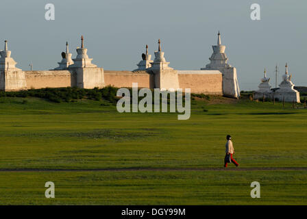 Mongolian woman walking devant le stupa de la paroi extérieure du monastère Erdene Zuu Khiid, Karakorum, Kharkhorin Banque D'Images