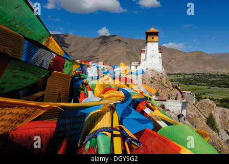 Volant au-dessus des drapeaux de prière le Yarlung valley sur Palais Yumbulagang, première et la plus ancienne forteresse dans le Tibet, Himalaya, Tibet central Banque D'Images