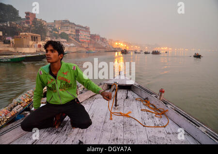 Batelier indiennes sur le Gange près les ghats à l'aube, Gange, Varanasi, Benares ou Kashi, Uttar Pradesh, Inde, Asie Banque D'Images