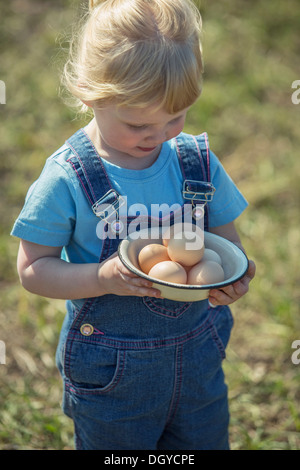 Farmer girl holding bol d'oeufs Banque D'Images