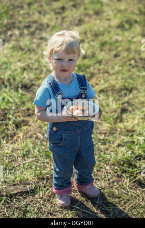 Farmer girl holding bol d'oeufs Banque D'Images