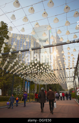 Les gens marcher sous les feux en forme de cloche, Zhujiang New Town, Guangzhou, Guangdong, Chine Banque D'Images