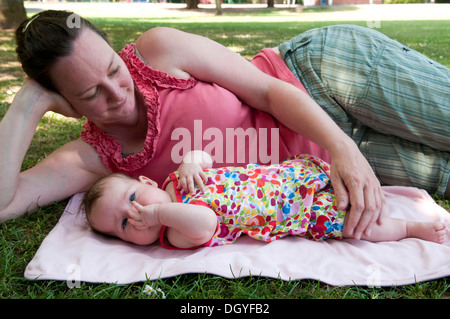 Mère câlin sa fille de bébé dehors dans le jardin Banque D'Images