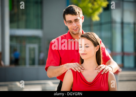 Business man giving massage de l'épaule de son collègue en plein air street Banque D'Images