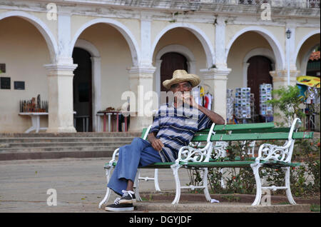 Homme assis sur le banc et fumer un gros cigare, Viñales, Cuba, Caraïbes, Amérique centrale Banque D'Images