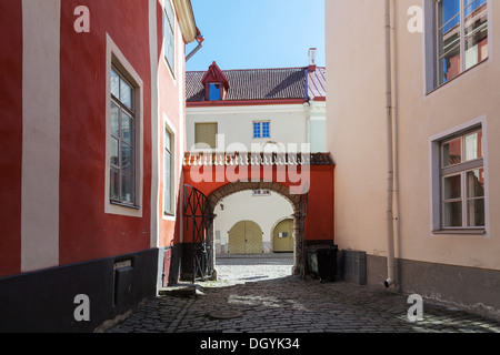 Vieille ville de Tallinn, fragment de rue avec arc rouge et portes de bois Banque D'Images