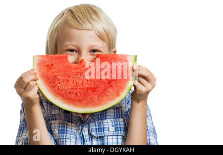 Un mignon happy smiling boy se cacher derrière une grosse tranche de pastèque juteuse. Isolé sur blanc. Banque D'Images