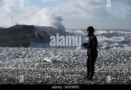 Brighton Sussex UK 28 octobre 2013 - Une femme marchant sur la plage près de Brighton Marina que les tempêtes les battues côte sud ce matin la tempête, appelé St Jude, a introduit le plus de vent, la météo à frapper le Royaume-Uni depuis 1987. Banque D'Images