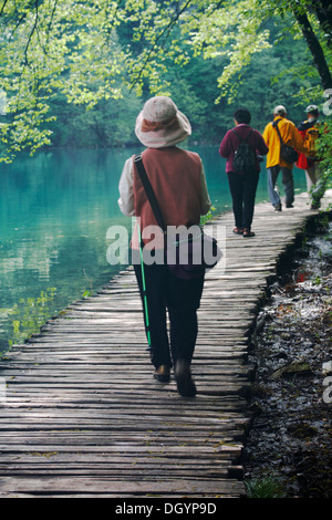 Touristes marchant le long du chemin de promenade en bois pour voir les cascades et les lacs du parc national des lacs de Plitvice site du patrimoine mondial de l'UNESCO en Croatie, mai Banque D'Images