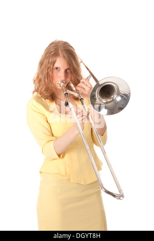 Jeune femme en jaune holding trombone et fond blanc Banque D'Images