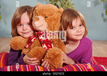 Les filles, jumeaux, six ans, avec l'ours Banque D'Images