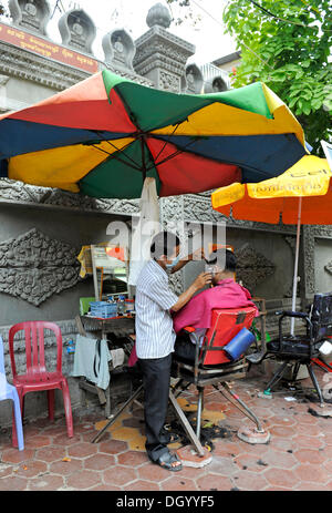 Salon de coiffure la coupe de cheveux dans un salon de plein air, Phnom Penh, Cambodge, Asie Banque D'Images