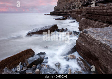 Surfez sur la côte rocheuse avec des falaises, Dunraven Bay, la côte du Glamorgan, Pays de Galles, Royaume-Uni Banque D'Images