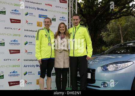 Dublin, Irlande. 28e Octobre 2013. Coureur irlandais Sean Hehir a remporté la course des hommes du marathon de Dublin 2013 Airtricity en 2:18:19. Il est le premier coureur irlandais à gagner le marathon en 20 ans. Eilis Fitzgerald (M) de l'Irlande, Renault présente les deux vainqueur du women's and men's race, Maria McCambridge (L) et Sean Hehir (R) avec une Renault Fluence ZE, une voiture électrique. Crédit : Michael Debets/Alamy Live News Banque D'Images