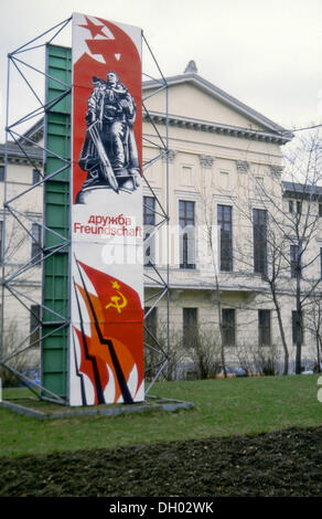 La propagande socialiste signe, Druzhba Freundschaft, russe et allemand pour l'amitié, avec des drapeaux de l'URSS en face d'un Banque D'Images