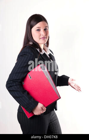 Businesswoman holding un dossier rouge dans son bras avec une attitude en question Banque D'Images