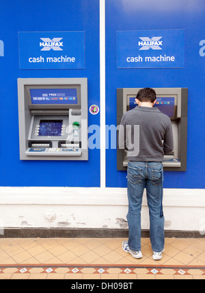 Un homme à percevoir de l'argent à partir d'un GAB de la banque Halifax cash machine, Norwich UK Banque D'Images