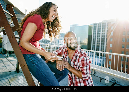 Couple relaxing on urban rooftop Banque D'Images