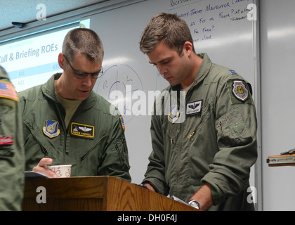 Le lieutenant-colonel Andrew Campbell, le directeur des opérations, et le Capitaine Matthew Andrews, un commandant de mission, à la fois avec 36e Escadron de transport aérien, vérifier la mission d'information pour une grande mission formation à Yokota Air Base, Japon, le 22 octobre 2013. La montée de l'aile à l'essai Banque D'Images