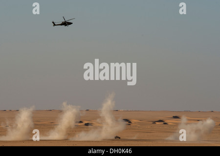 Une armée américaine d'hélicoptères AH-64 Apache à partir de la 36e Brigade d'aviation banques sur smoky vestiges de son conjoint au cours d'une attaque à la roquette Banque D'Images