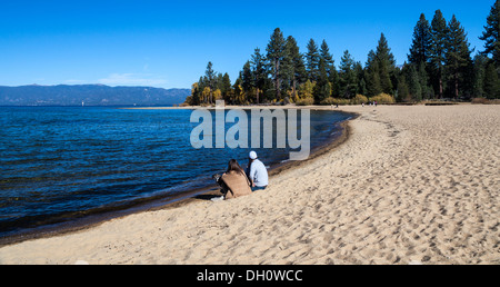 Couple avec chien profitez de vues à Kiva Beach à Lake Tahoe Banque D'Images