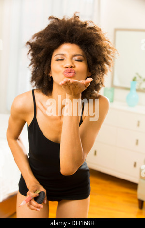 Mixed Race woman blowing a kiss Banque D'Images