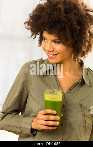 Mixed Race woman drinking smoothie vert Banque D'Images