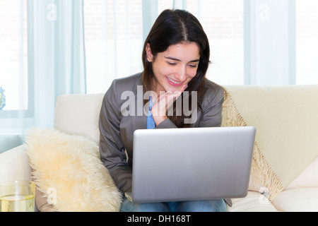 Hispanic woman on sofa Banque D'Images