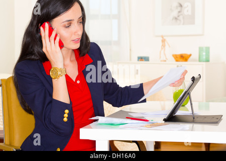 Mixed Race businesswoman working at desk Banque D'Images