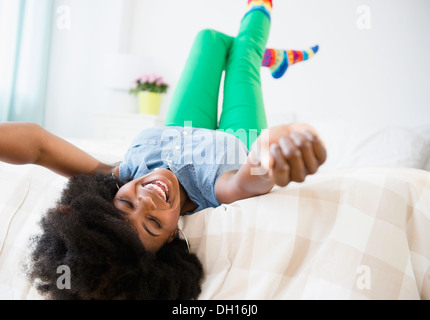 Mixed Race woman smiling on bed Banque D'Images