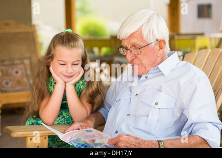 L'homme de race blanche et petite-fille de la lecture en plein air Banque D'Images