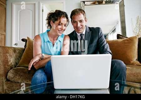 Caucasian couple using laptop in living room Banque D'Images