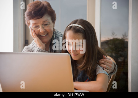 Plus Hispanic woman using laptop with granddaughter Banque D'Images