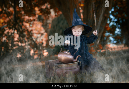 Peu d'halloween sorcière , une potion d'ébullition, en plein air dans les bois Banque D'Images