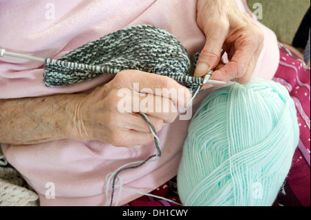 Femme âgée un vêtement de tricot - knitting n'est pas seulement un grand passe-temps / intérêt mais aide à garder le cerveau actif. Ce retraité a un mauvais arthritiritis Banque D'Images