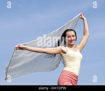 Femme tenant un tissu blanc dans le vent Banque D'Images