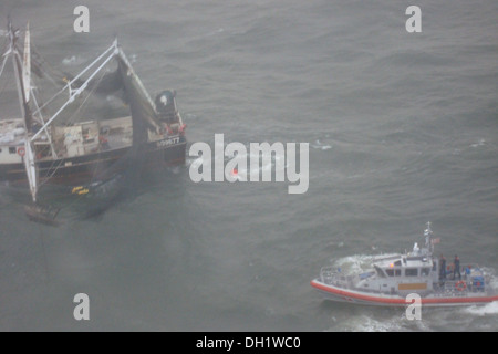 Un boatcrew La Garde côtière à bord d'un bateau d'intervention de 45 pieds - moyenne à partir de la gare de Mayport Atlantic Beach, en Floride, adopte une pompe d'assèchement pour les 88 pieds bateau crevette Sea King, qui a commencé à prendre l'eau avec quatre personnes à bord de 2 miles au large de Ponte Vedra, Fla., T Banque D'Images