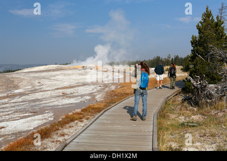 Les touristes en haut à Geyser Basin, Parc National de Yellowstone, Wyoming, USA Banque D'Images