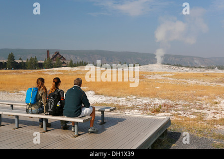 Les touristes en attente de l'éruption de l'Old Faithful, Upper Geyser Basin, Parc National de Yellowstone, Wyoming, USA Banque D'Images