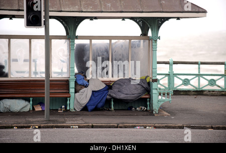 Lit dans un sac de couchage dans un front de mer de Brighton abri pendant la journée Banque D'Images