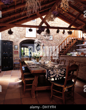 Table et chaises en bois rustique en coin repas de grande cuisine espagnole, sol en terre cuite et poutres au plafond plancher rustique Banque D'Images