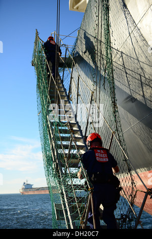 Le secteur de la Garde côtière de la rivière Columbia d'embarquement de l'équipage du navire de l'équipe de sécurité à bord d'un navire d'expédition montée sur le fleuve Columbia off de Astoria, Oregon, le 21 octobre, 2013. L'équipe de sécurité à bord du navire est utilisé pour inspecter les navires arrivant dans les ports américains après Banque D'Images