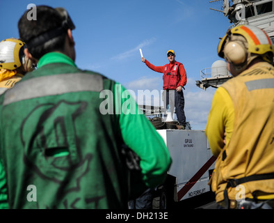 Maître de Manœuvre de l'aviation (manutention) 1re classe Matthieu Belke donne un bref avant un exercice incendie sur le pont du porte-avions USS Nimitz (CVN 68). Nimitz est déployé des opérations de sécurité maritime et de coopération en matière de sécurité dans le théâtre Banque D'Images