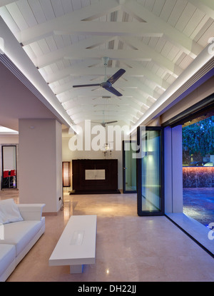 Table basse et canapé blanc en face de portes de verre dans la salle de séjour avec poutres apparentes au plafond blanc apex en espagnol nouvellement construit villa Banque D'Images