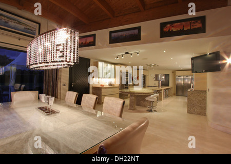 Glass beaded luminaire au-dessus de table en verre et chaises capitonnées en coin repas en villa récemment construite en Espagne Banque D'Images