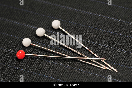 Les broches se trouvant sur le tissu de coton à rayures noires Banque D'Images