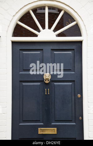 Porte avant - détail de maison traditionnel anglais avec heurtoir lion en laiton, laiton boîte aux lettres et un numéro 11 en laiton Banque D'Images