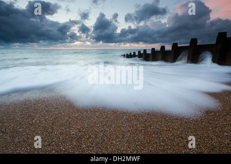 Roulement des vagues sur la plage au lever du soleil Banque D'Images