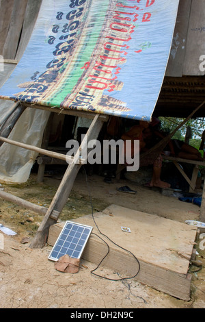 Un petit panneau solaire portable fournit de l'électricité pour les maisons en bois près d'un grand dépotoir à Phnom Penh, Cambodge. Banque D'Images