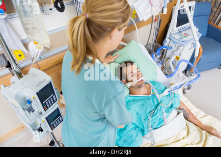 Réglage de l'infirmière jeune patient's Pillow à l'hôpital Banque D'Images